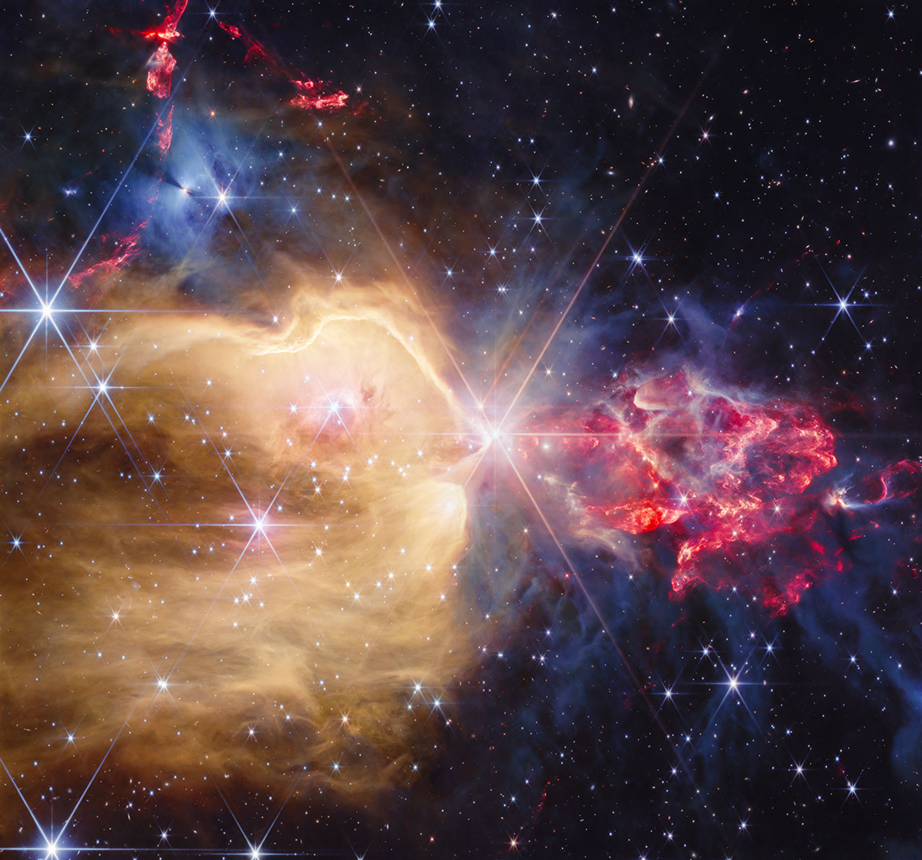 Imagen astronómica real de NGC 7129 tomada con NIRCam del telescopio Webb, con datos infrarrojos representados en colores.