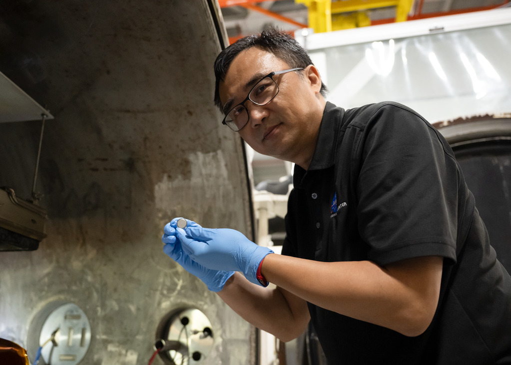 Yi Lin sostiene una pequeña celda SPEARS junto a una cámara de pruebas en NASA Langley; fotografía del proyecto difundida el 14 de octubre de 2026.