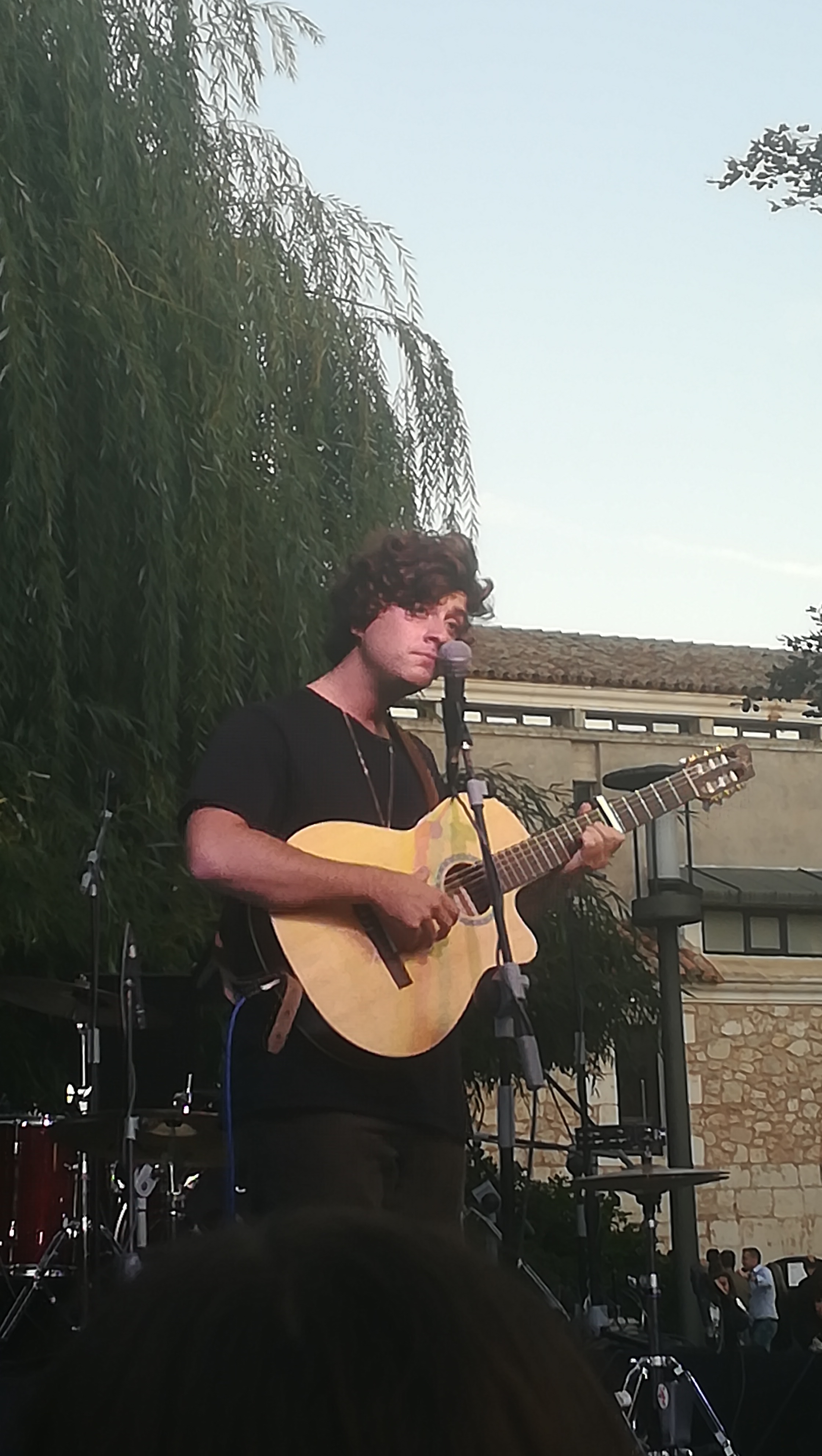 Guitarricadelafuente canta con una guitarra en un escenario al aire libre en Burgos; fotografía de archivo de septiembre de 2019, no del recital de Madrid.