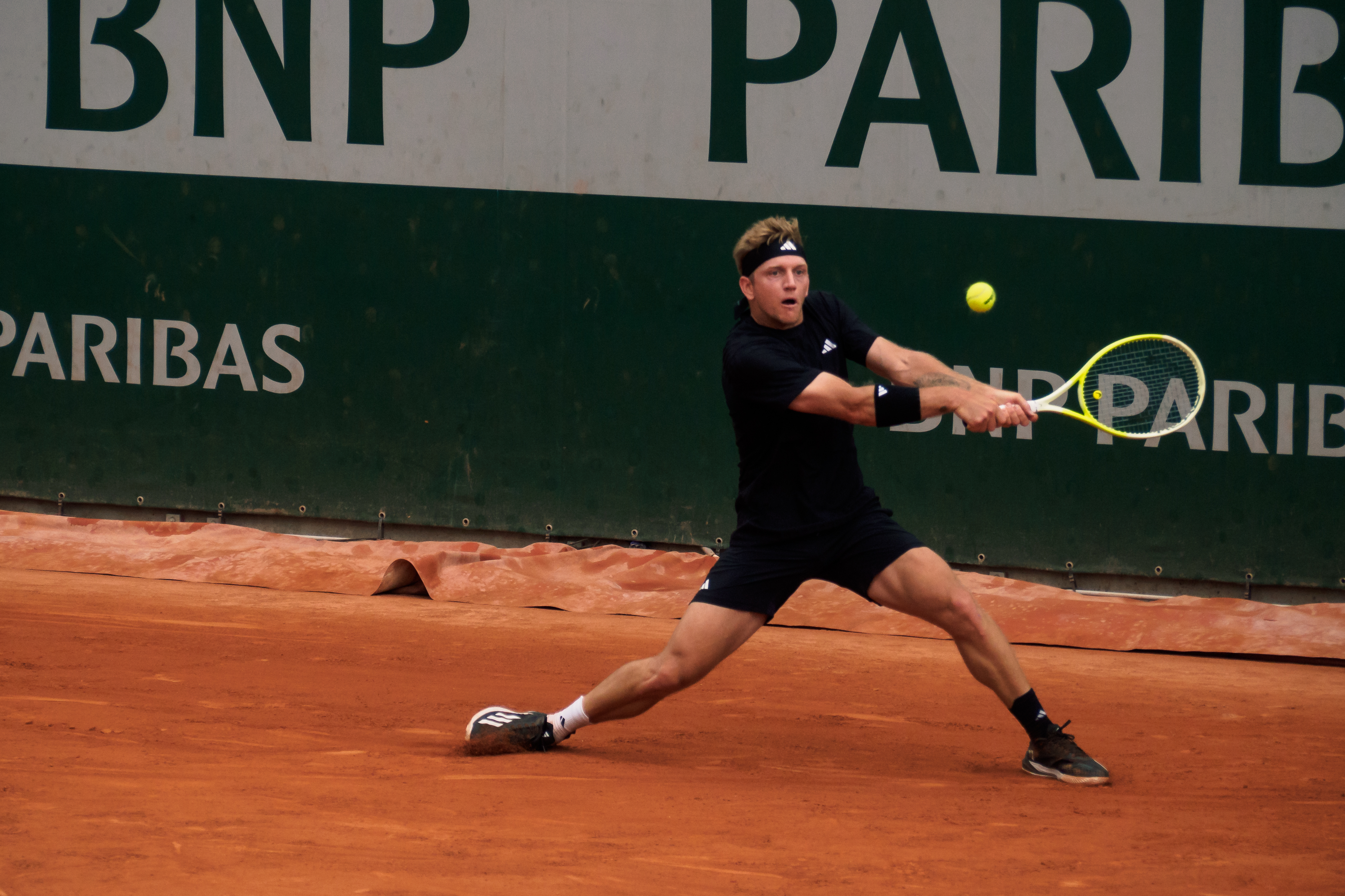 Alejandro Davidovich Fokina ejecuta un revés en Roland Garros el 26 de mayo de 2025, vestido de negro. Fotografía de archivo; no corresponde a la semifinal de Shanghái de 2026.