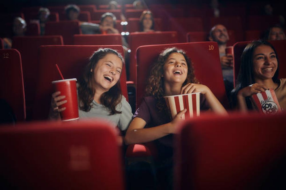 Interior de una sala de cine con butacas y pantalla.