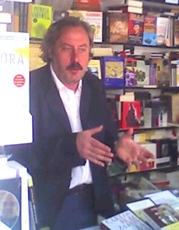 Foto de archivo de Julio Llamazares junto a una estantería de libros en la Feria del Libro de Madrid; no corresponde al anuncio del premio de 2026.