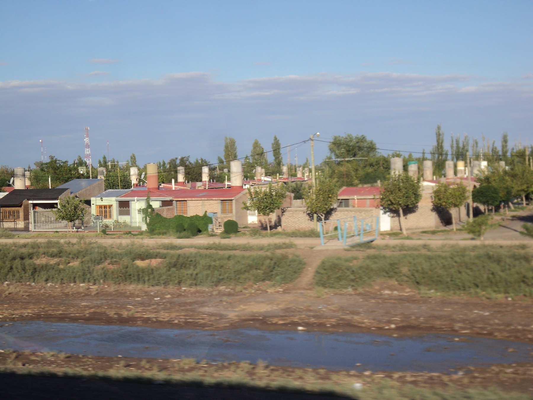 Vista de viviendas y una banquina con agua en Media Agua, Sarmiento, San Juan. Fotografía de archivo incorporada a Commons en abril de 2013; fecha exacta de captura no confirmada.