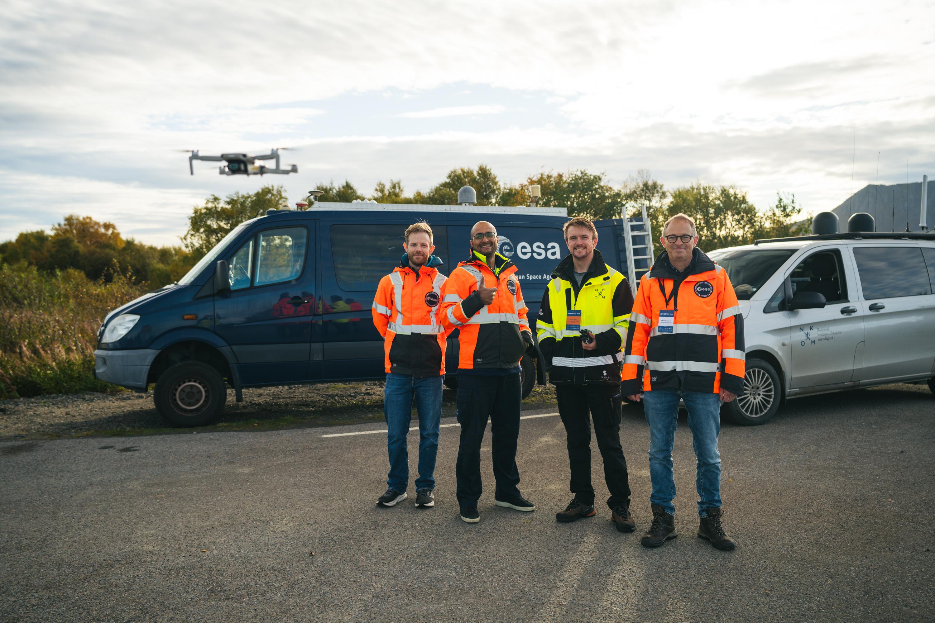 Equipo de pruebas junto a un dron en vuelo y vehículos de laboratorio durante Jammertest 2026 en Noruega, en septiembre.