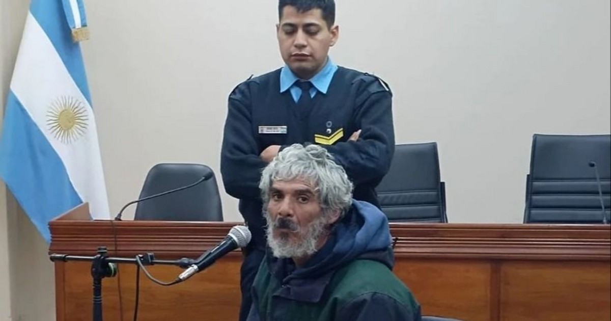 Un hombre declara ante un tribunal con un agente de seguridad detrás.