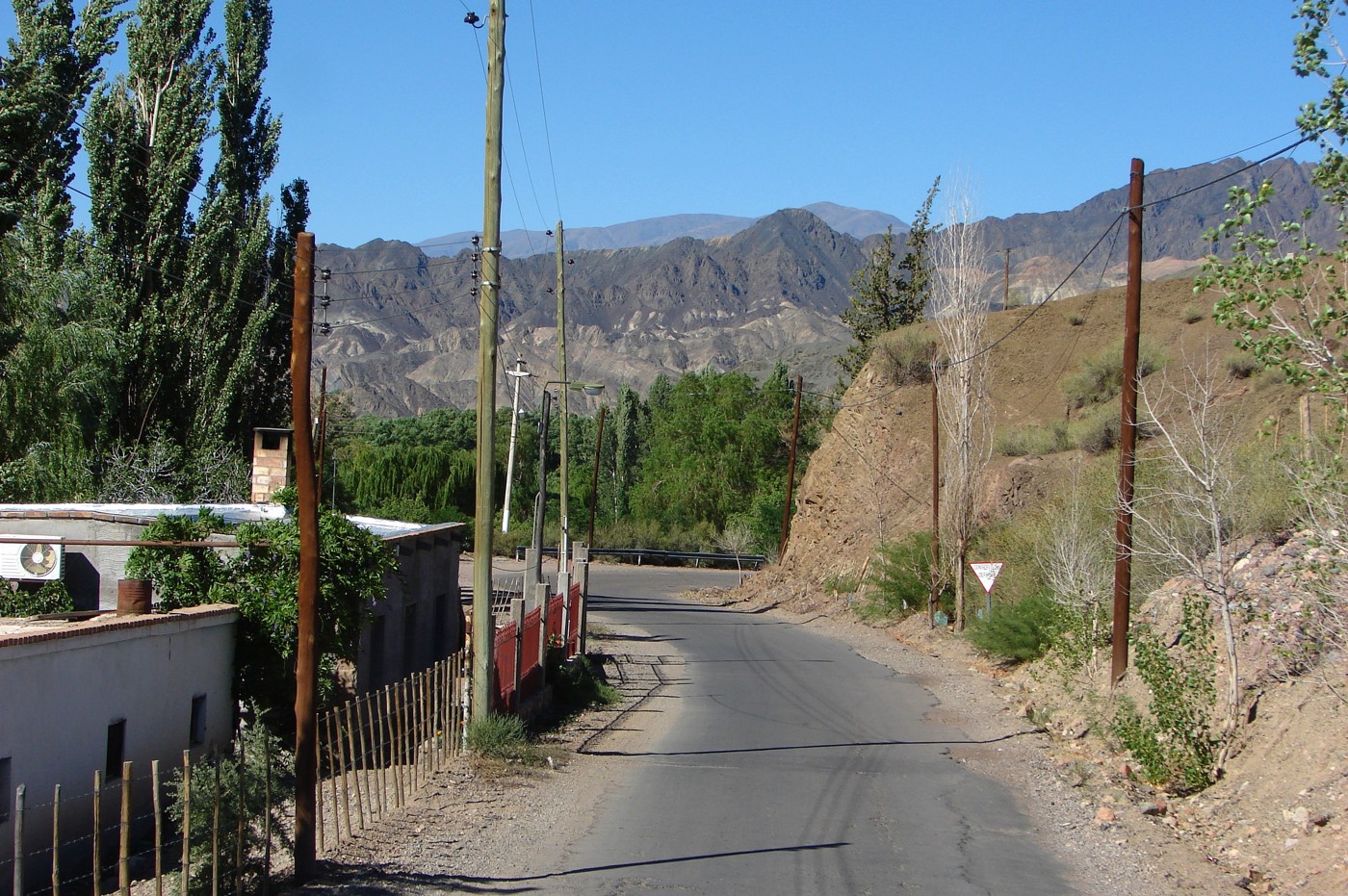 Calle de Calingasta con viviendas, árboles y montañas. Fotografía de archivo del 28 de noviembre de 2013; no registra el episodio de Zonda previsto para octubre de 2026.