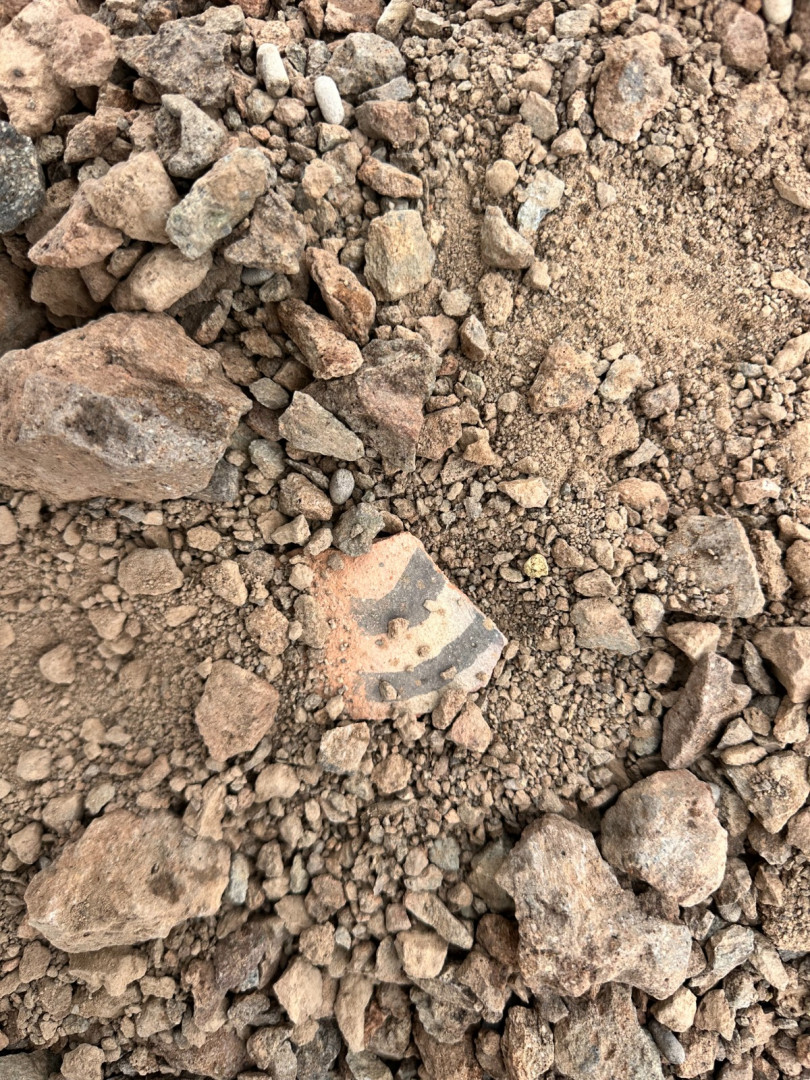 Fragmento cerámico decorado entre piedras en el hallazgo cordillerano difundido por Gendarmería el 13 de octubre de 2026.