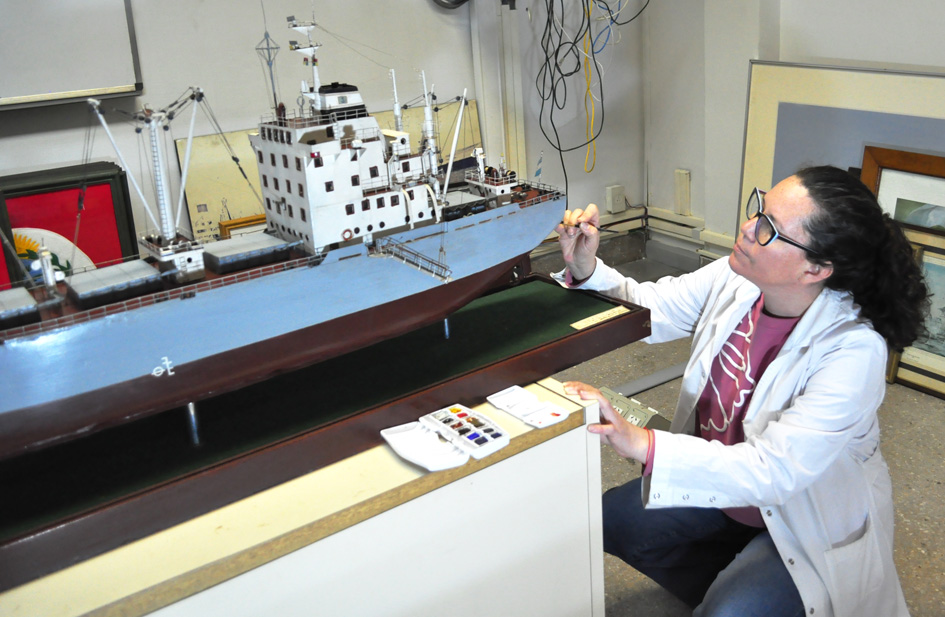 Una restauradora trabaja con un pincel sobre la maqueta del buque Salta en el taller del Ministerio de Economía, en una fotografía difundida el 14 de octubre de 2026.